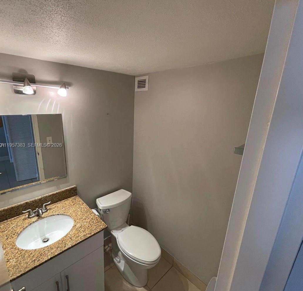 16909 North Bay Road, Unit 807 Sunny Isles Beach, FL 33160 - Photo 13 of 15 a bathroom with a granite countertop sink a toilet and a mirror