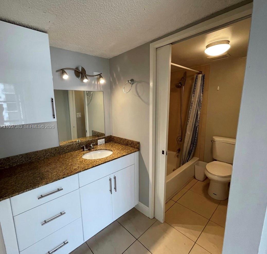 16909 North Bay Road, Unit 807 Sunny Isles Beach, FL 33160 - Photo 14 of 15 a spacious bathroom with a granite countertop sink toilet and mirror