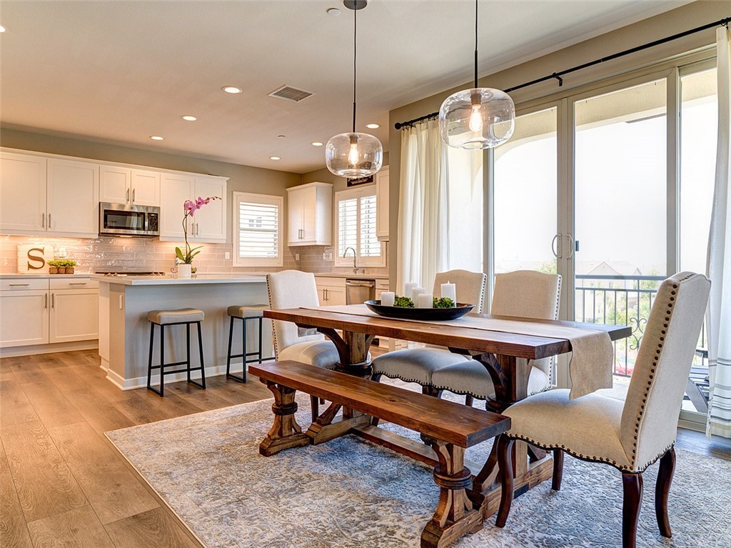 a dining room with a table chairs and a kitchen view