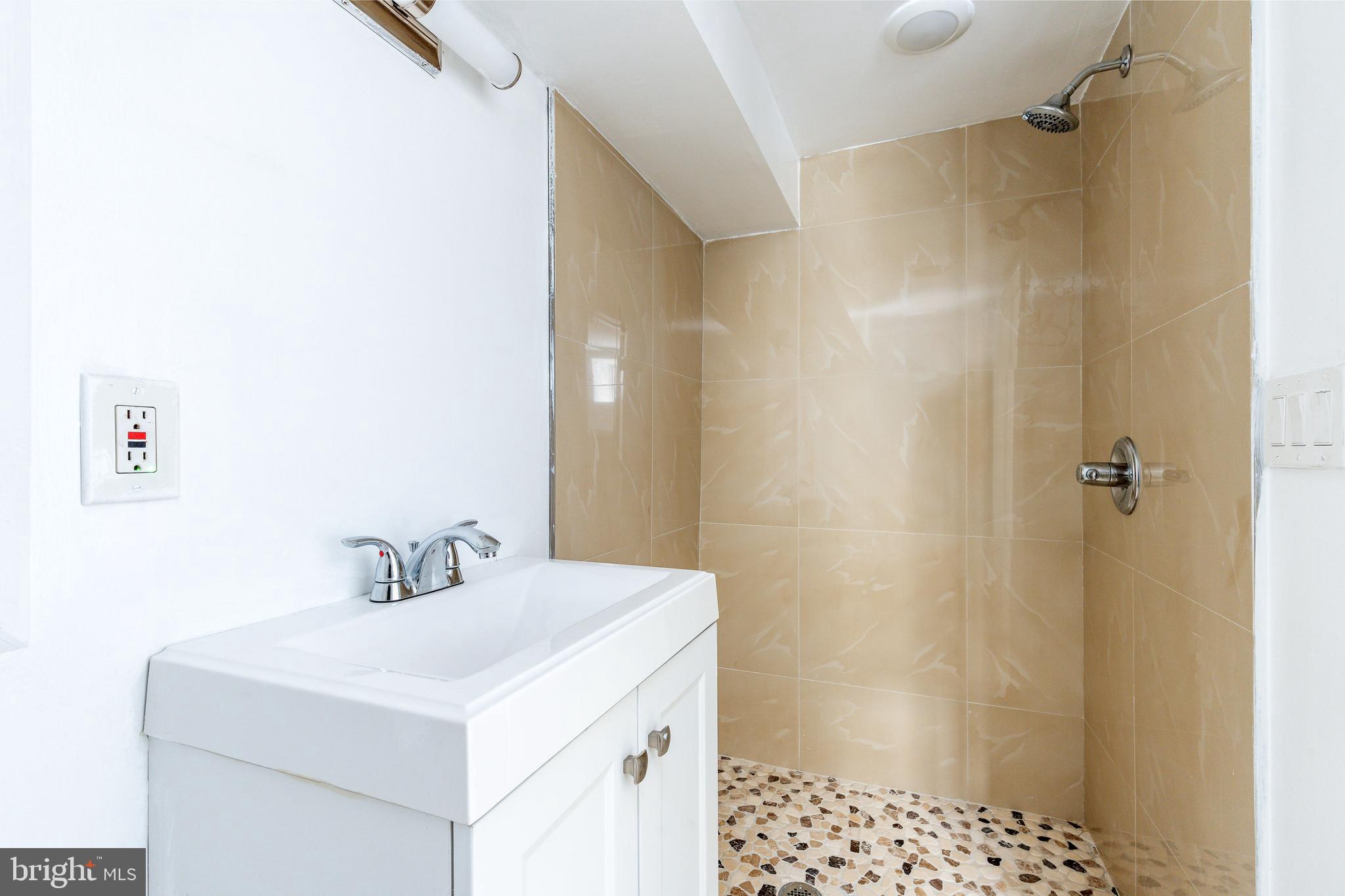 2726 Edgemont Street Philadelphia, PA 19134 - Photo 12 of 32 a bathroom with a sink a shower and a mirror