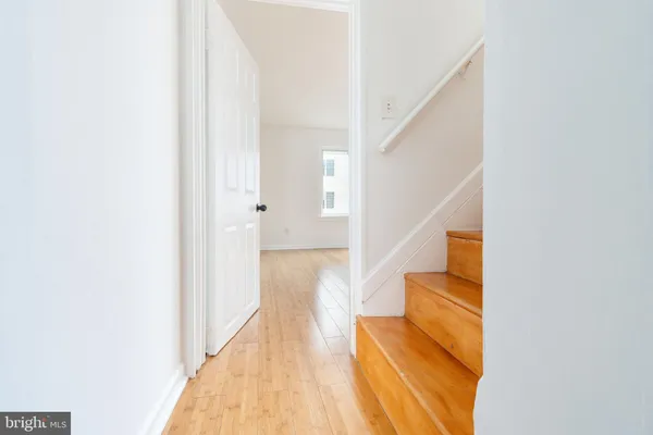 a view of a hallway with wooden floor and staircase