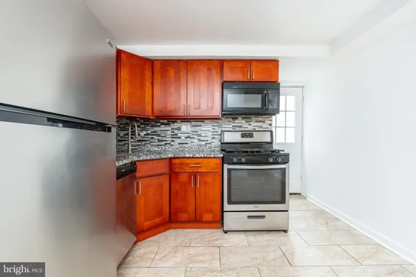 a kitchen with stainless steel appliances a stove microwave and sink