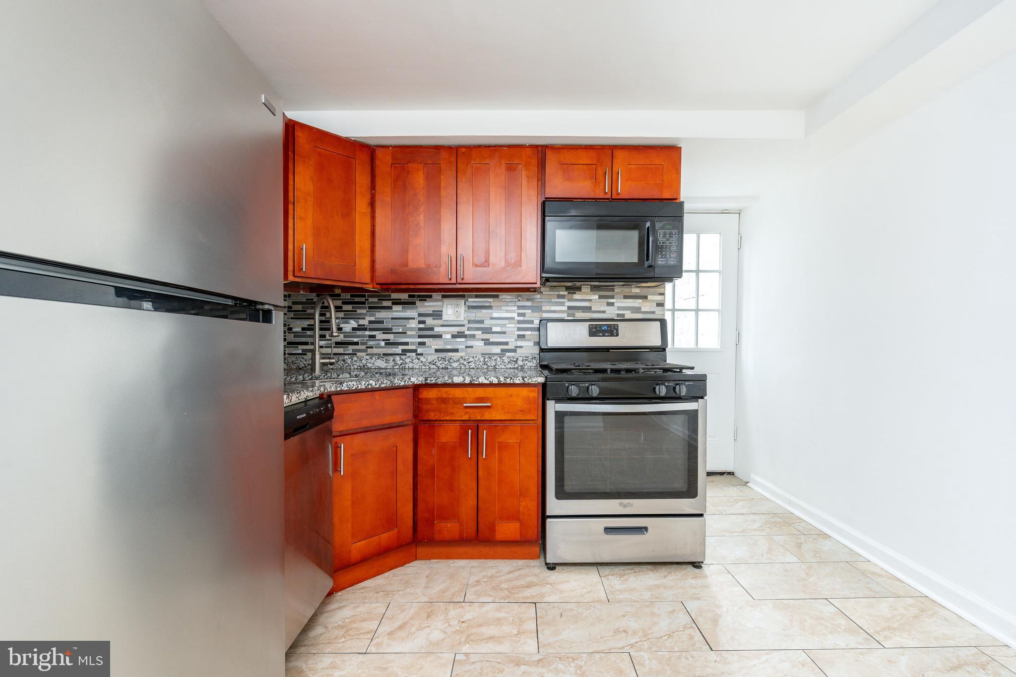 2726 Edgemont Street Philadelphia, PA 19134 - Photo 6 of 32 a kitchen with stainless steel appliances a stove microwave and sink