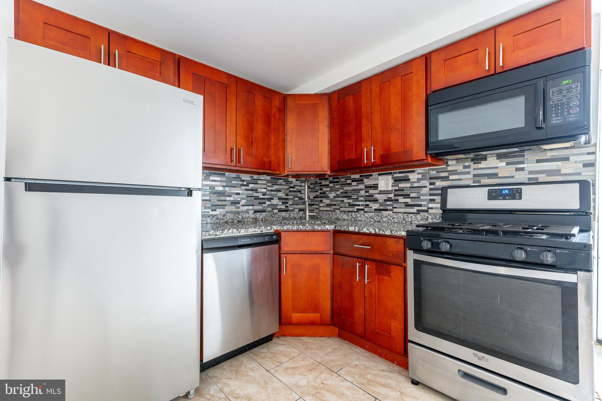 2726 Edgemont Street Philadelphia, PA 19134 - Photo 7 of 32 a kitchen with stainless steel appliances a stove microwave and refrigerator