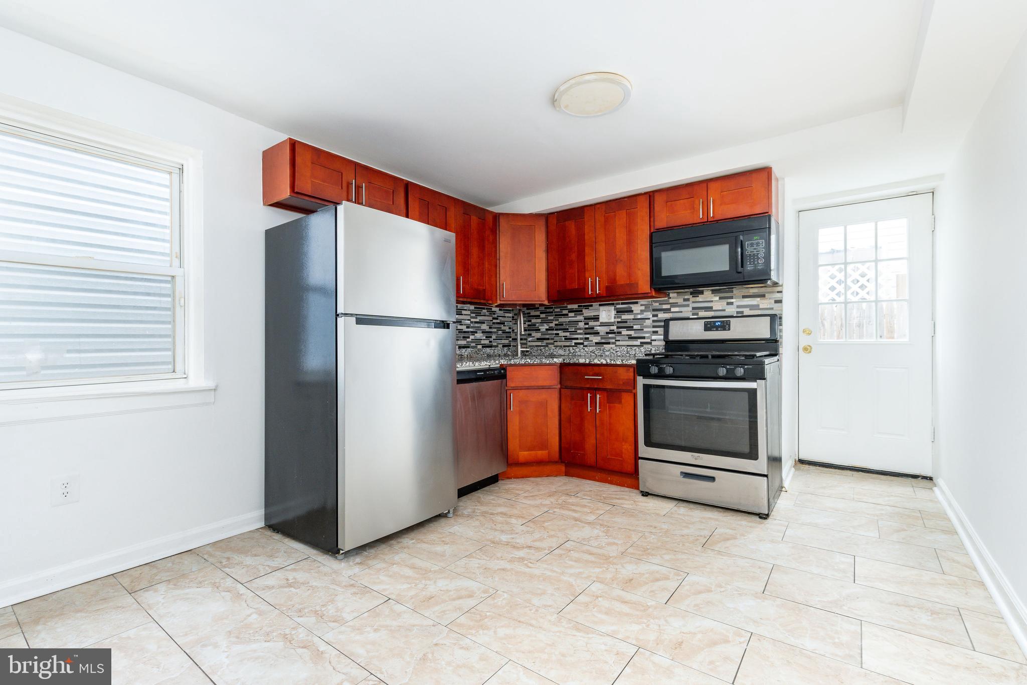 2726 Edgemont Street Philadelphia, PA 19134 - Photo 8 of 32 a kitchen with stainless steel appliances a stove and a refrigerator