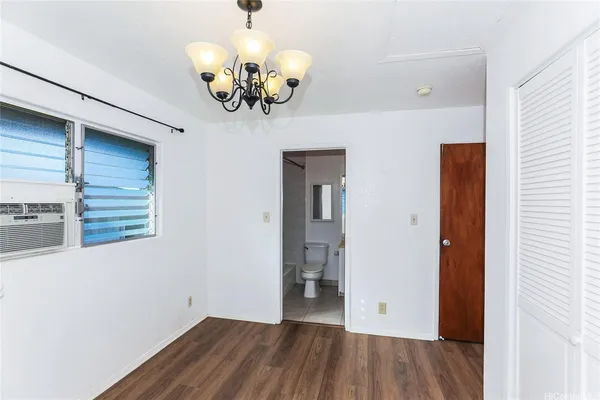 a view of a room with wooden floor and chandelier