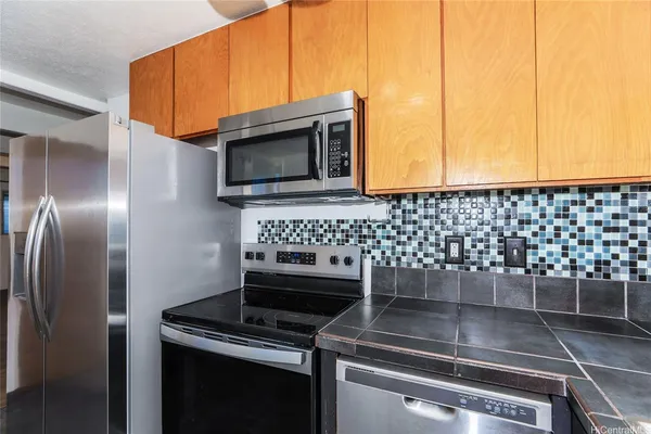 a kitchen with granite countertop a stove and a microwave