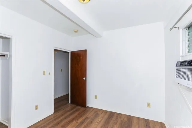 a view of an empty room with closet and a window
