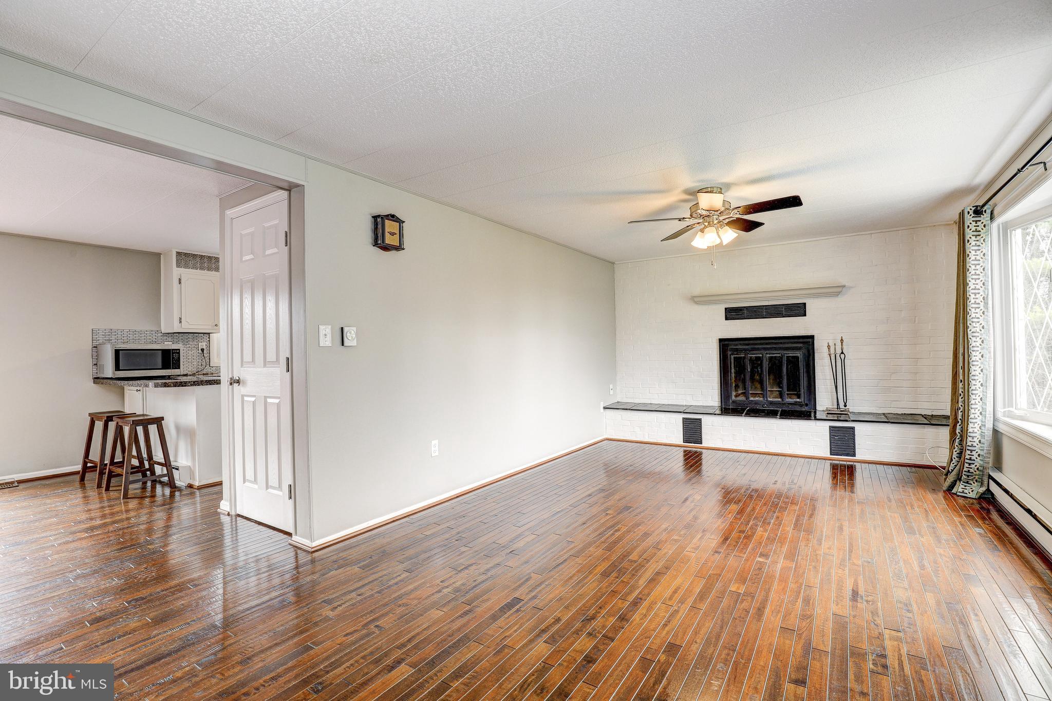 21329 Middletown Road Freeland, MD 21053 - Photo 6 of 37 a view of a livingroom with wooden floor and a kitchen