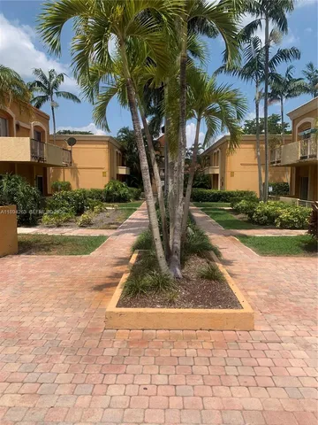 a view of a building with a yard and potted plants