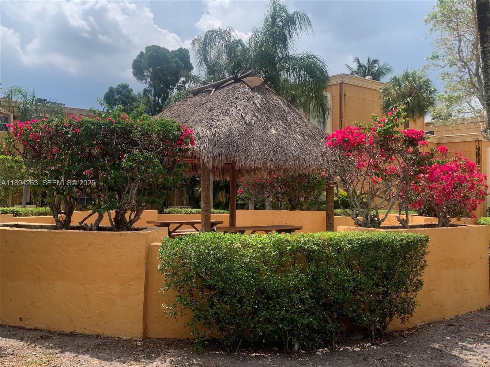17901 Northwest 68th Avenue, Unit Q103 Hialeah, FL 33015 - Photo 27 of 33 a view of a garden with flowers and trees