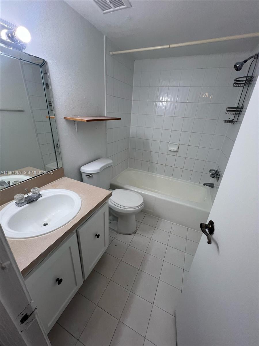 17901 Northwest 68th Avenue, Unit Q103 Hialeah, FL 33015 - Photo 3 of 33 a bathroom with a double vanity sink toilet and shower