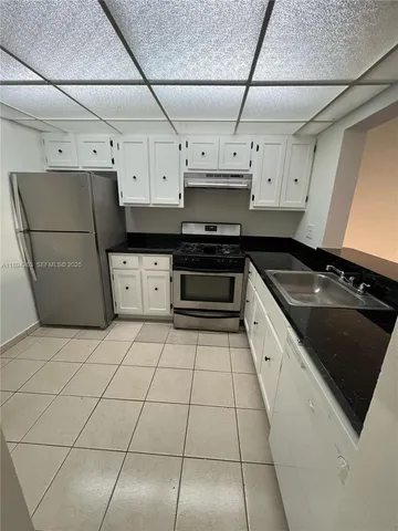 a kitchen with stainless steel appliances granite countertop a stove a sink dishwasher and a refrigerator