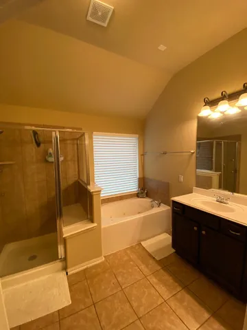 a spacious bathroom with a tub sink and mirror