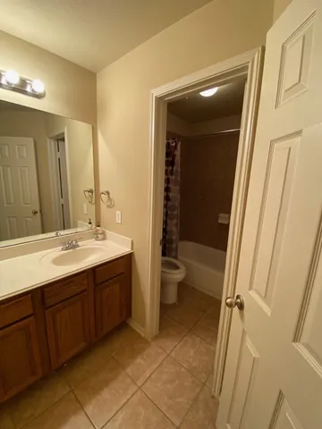 a bathroom with a double vanity sink toilet and shower