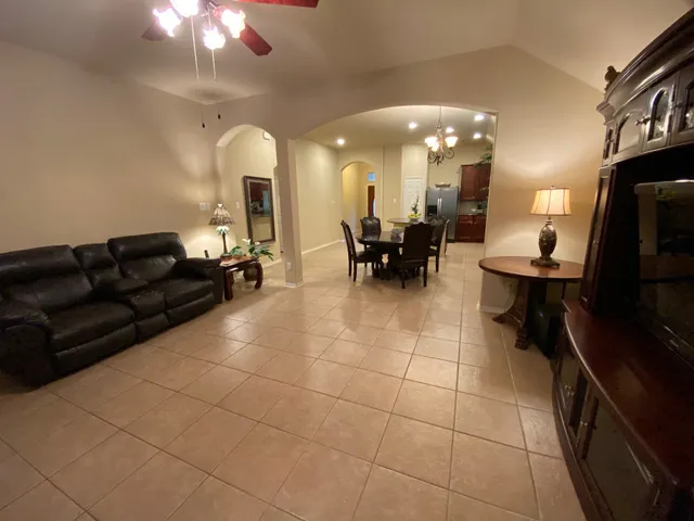 a living room with furniture a dining table and a chandelier