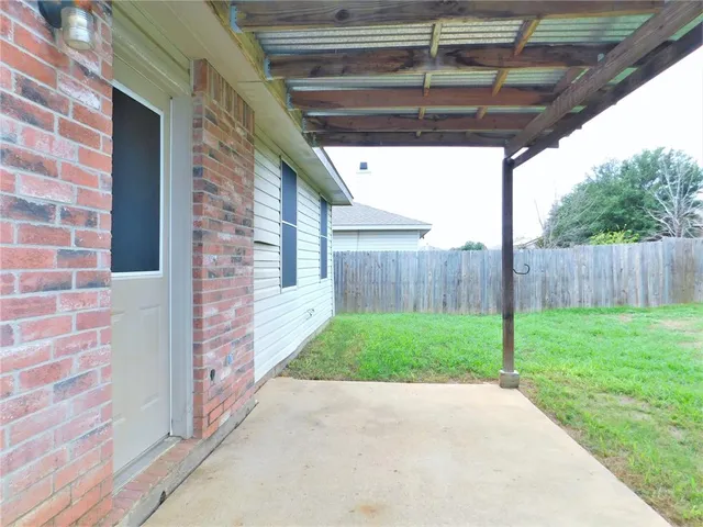 a view of a backyard with plants and wooden fence