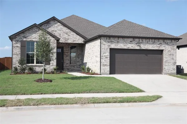a front view of a house with a garden and yard