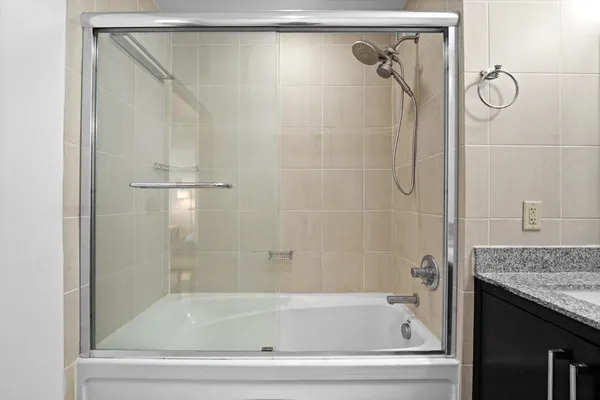 a bathroom with a granite countertop bathtub shower and vanity