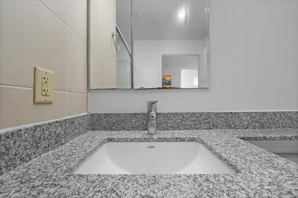 a bathroom with a bathtub sink and mirror