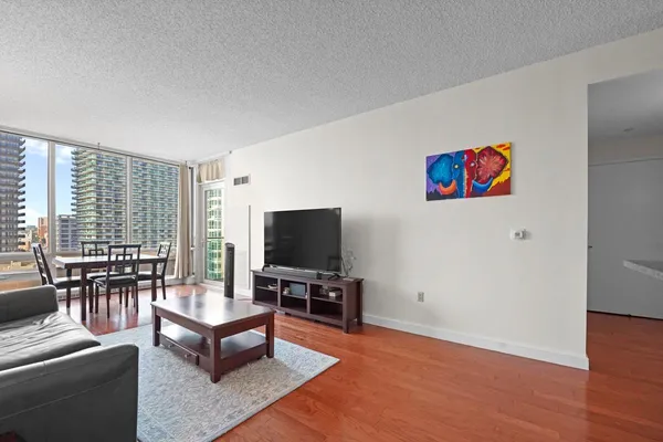 a living room with furniture and a flat screen tv with wooden floor