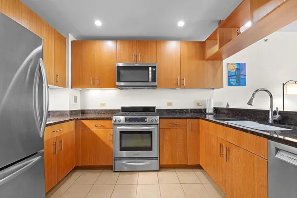a kitchen with stainless steel appliances granite countertop a sink stove and microwave