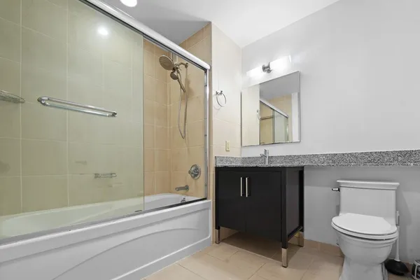 a bathroom with a granite countertop sink toilet and shower