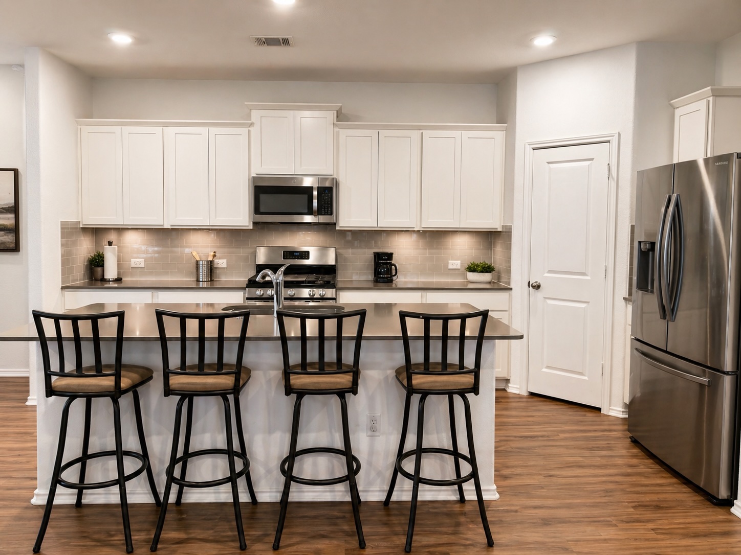 108 Blue Blaze Trail Georgetown, TX 78628 - Photo 5 of 26 a kitchen with stainless steel appliances granite countertop a table chairs refrigerator and microwave