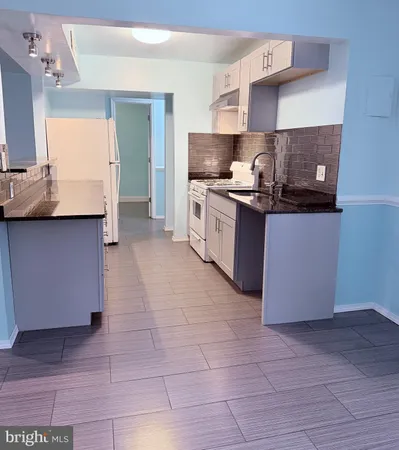 a kitchen with a sink a counter top space and cabinets