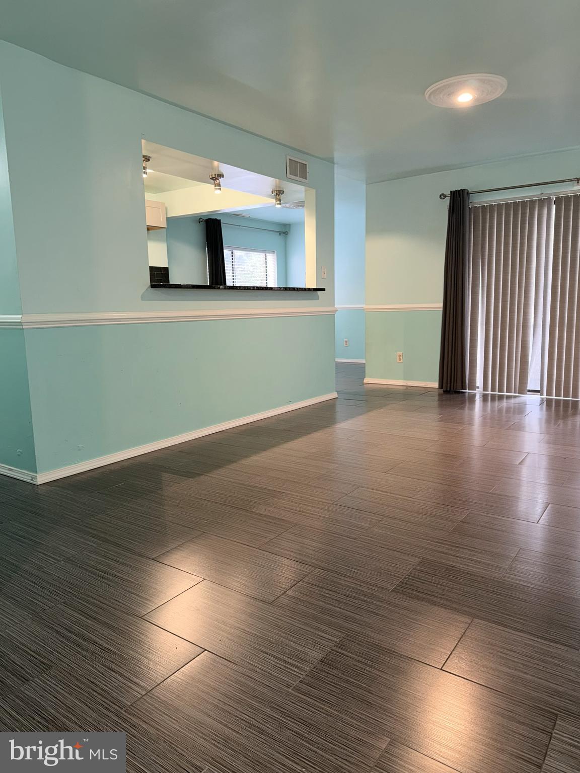 11206 Cherry Hill Road, Unit 92 Beltsville, MD 20705 - Photo 5 of 18 an empty room with wooden floor and a kitchen