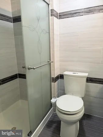 a white toilet sitting next to a bath tub