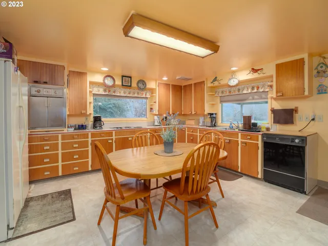 a kitchen with stainless steel appliances kitchen island granite countertop a table and chairs