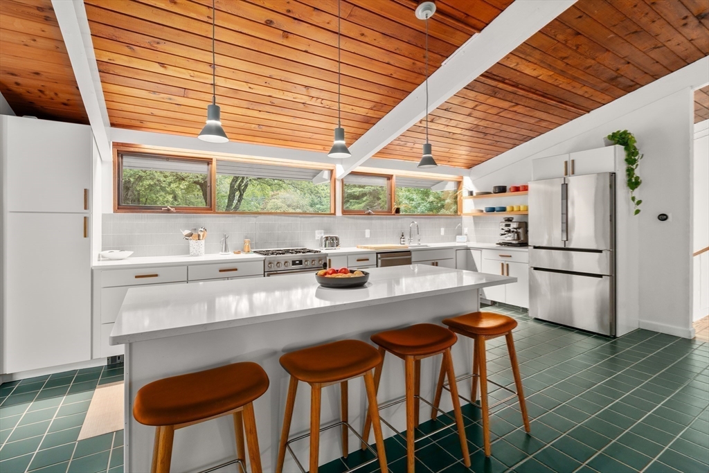 43 Willowdale Road Topsfield, MA 01983 - Photo 8 of 34 a kitchen with stainless steel appliances granite countertop a stove a refrigerator a kitchen island with a stove and white cabinets