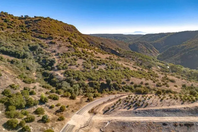 a view of a dry yard with mountains in the background