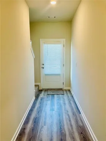 an empty room with wooden floor and doors