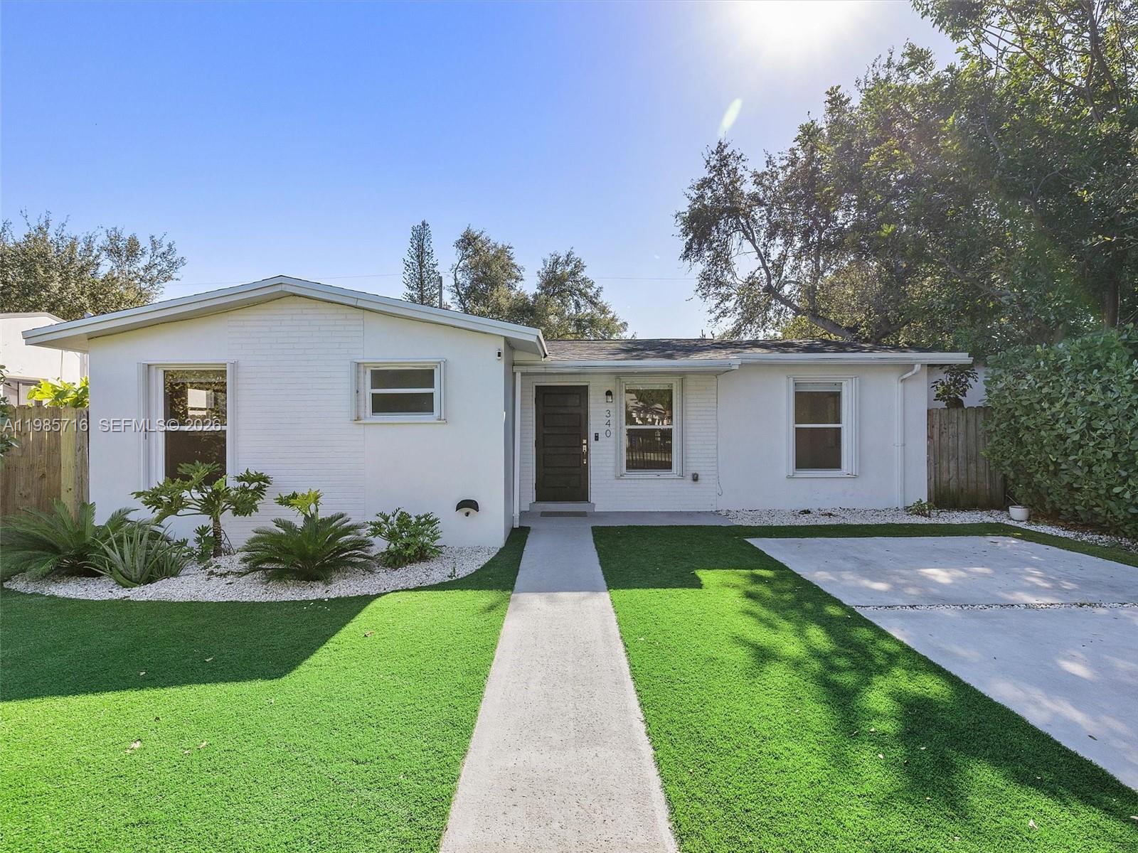 340 Northwest 45th Street Miami, FL 33127 - Photo 1 of 25 a front view of a house with a yard and potted plants