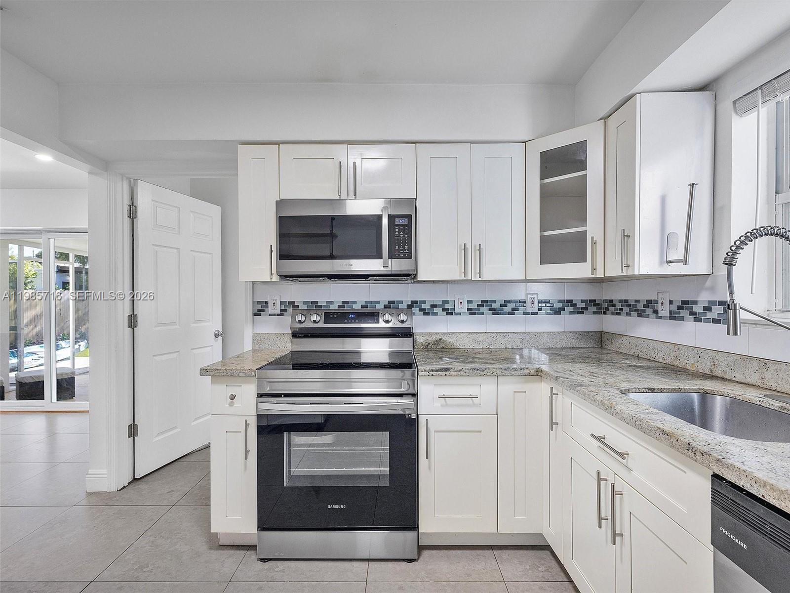 340 Northwest 45th Street Miami, FL 33127 - Photo 15 of 25 a kitchen with white cabinets stainless steel appliances and sink