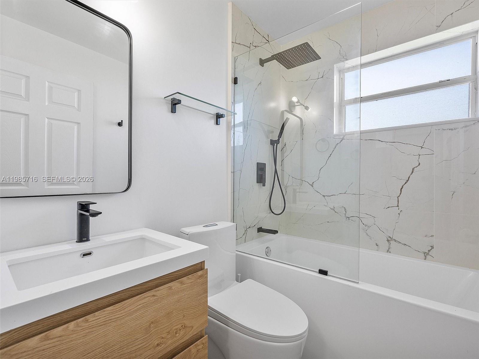 340 Northwest 45th Street Miami, FL 33127 - Photo 23 of 25 a bathroom with a toilet sink a mirror and shower