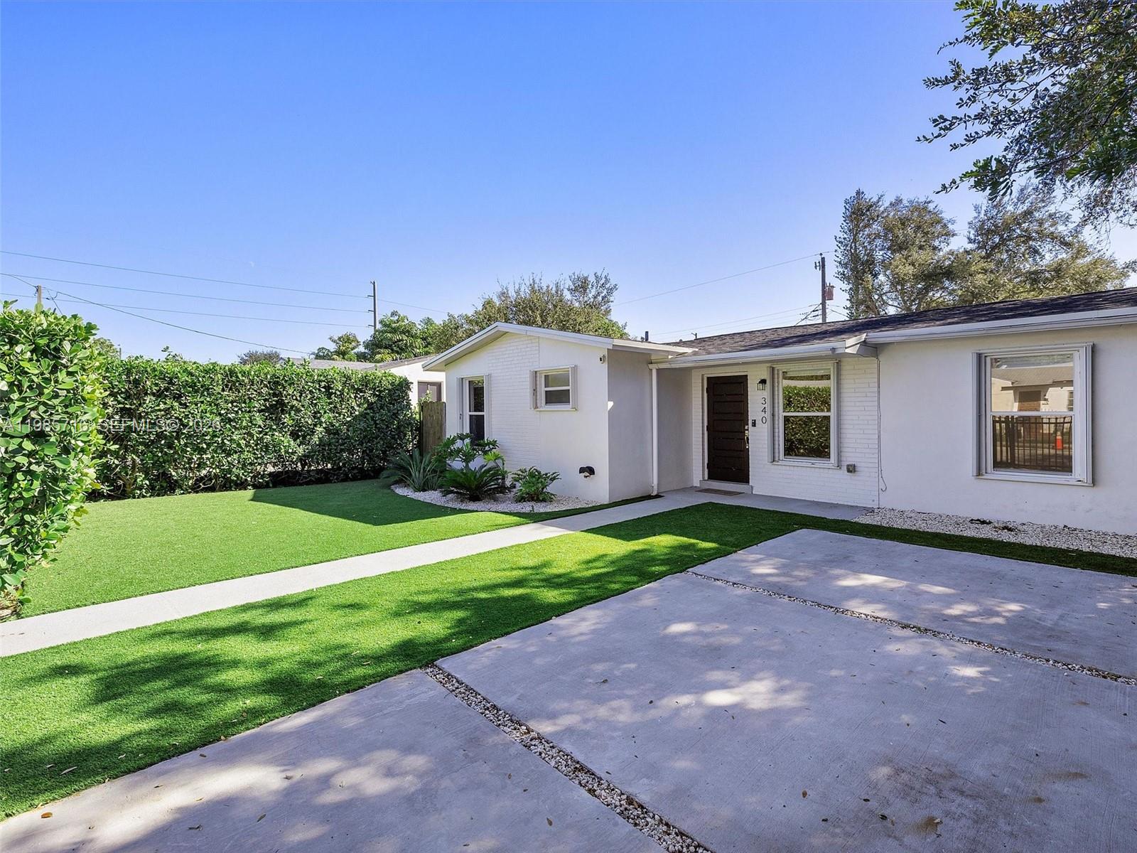 340 Northwest 45th Street Miami, FL 33127 - Photo 3 of 25 a view of a house with a yard and garage