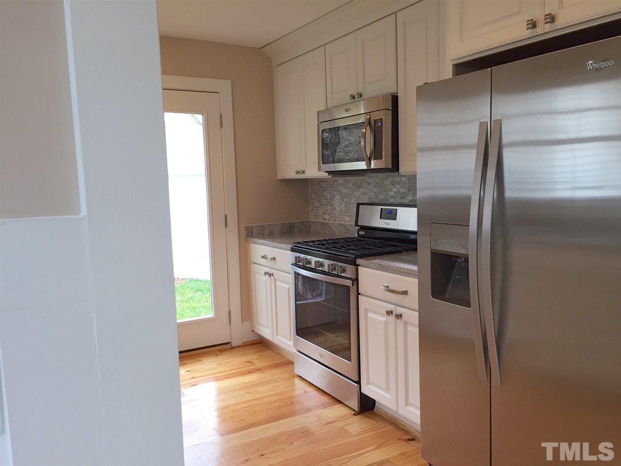 3132 Stanhope Avenue Raleigh, NC 27607 - Photo 4 of 11 a kitchen with stainless steel appliances granite countertop a refrigerator a stove a microwave and a sink