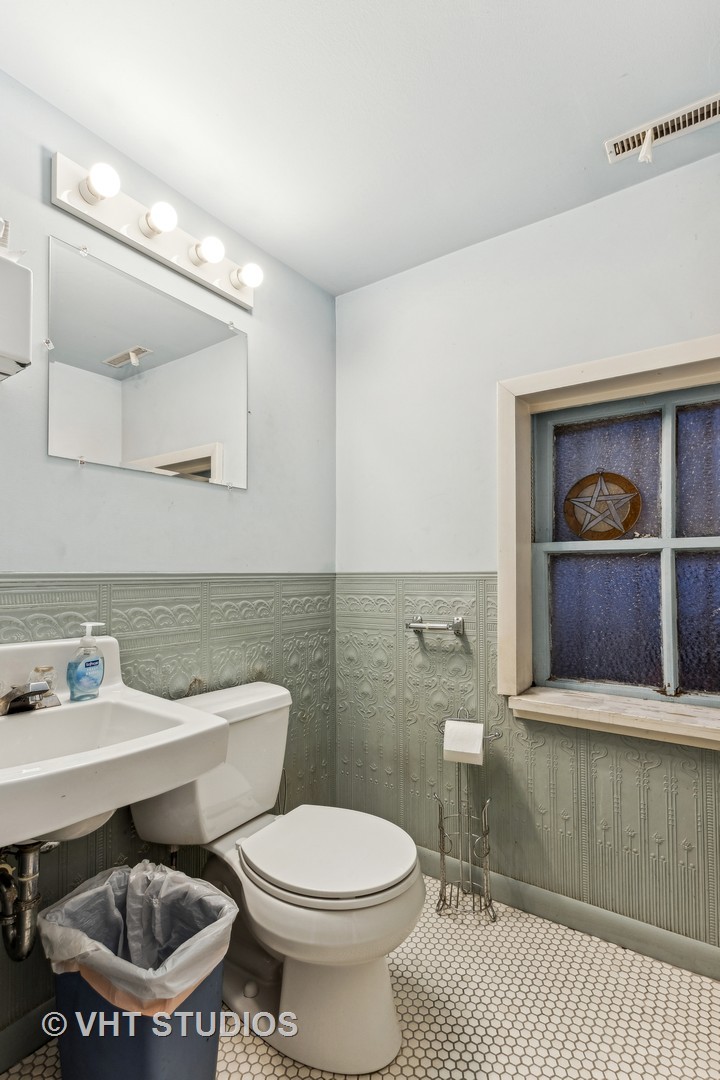 1622 West Devon Avenue Chicago, IL 60626 - Photo 25 of 36 a bathroom with a sink a toilet and a mirror