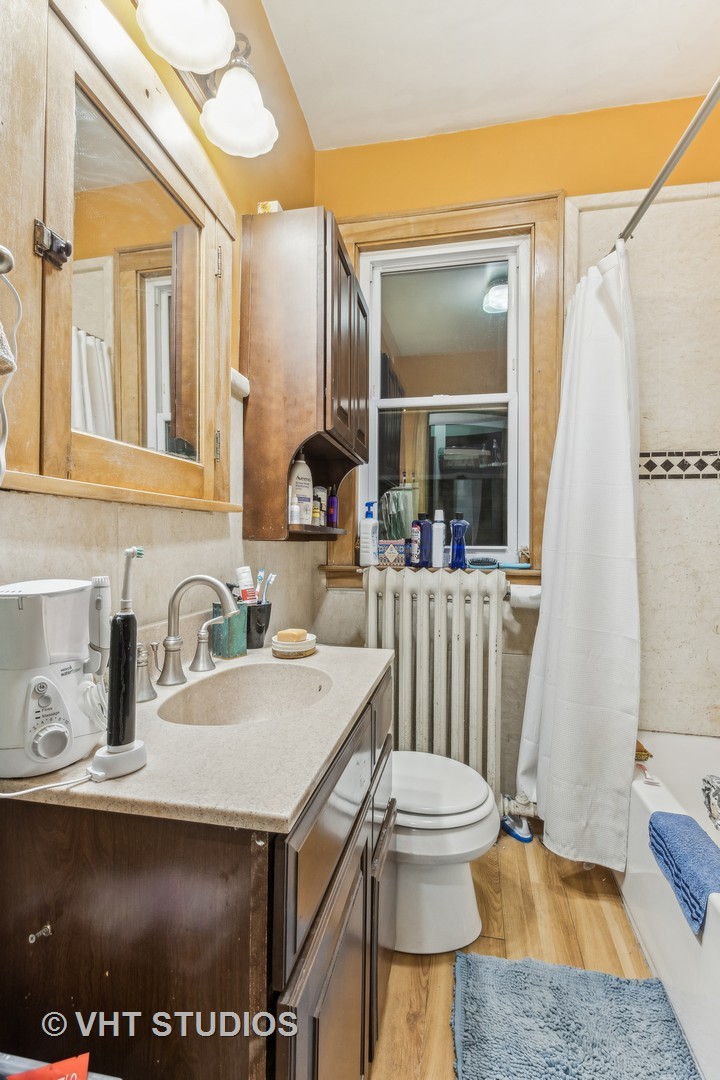 1622 West Devon Avenue Chicago, IL 60626 - Photo 8 of 36 a bathroom with a sink a toilet and a mirror