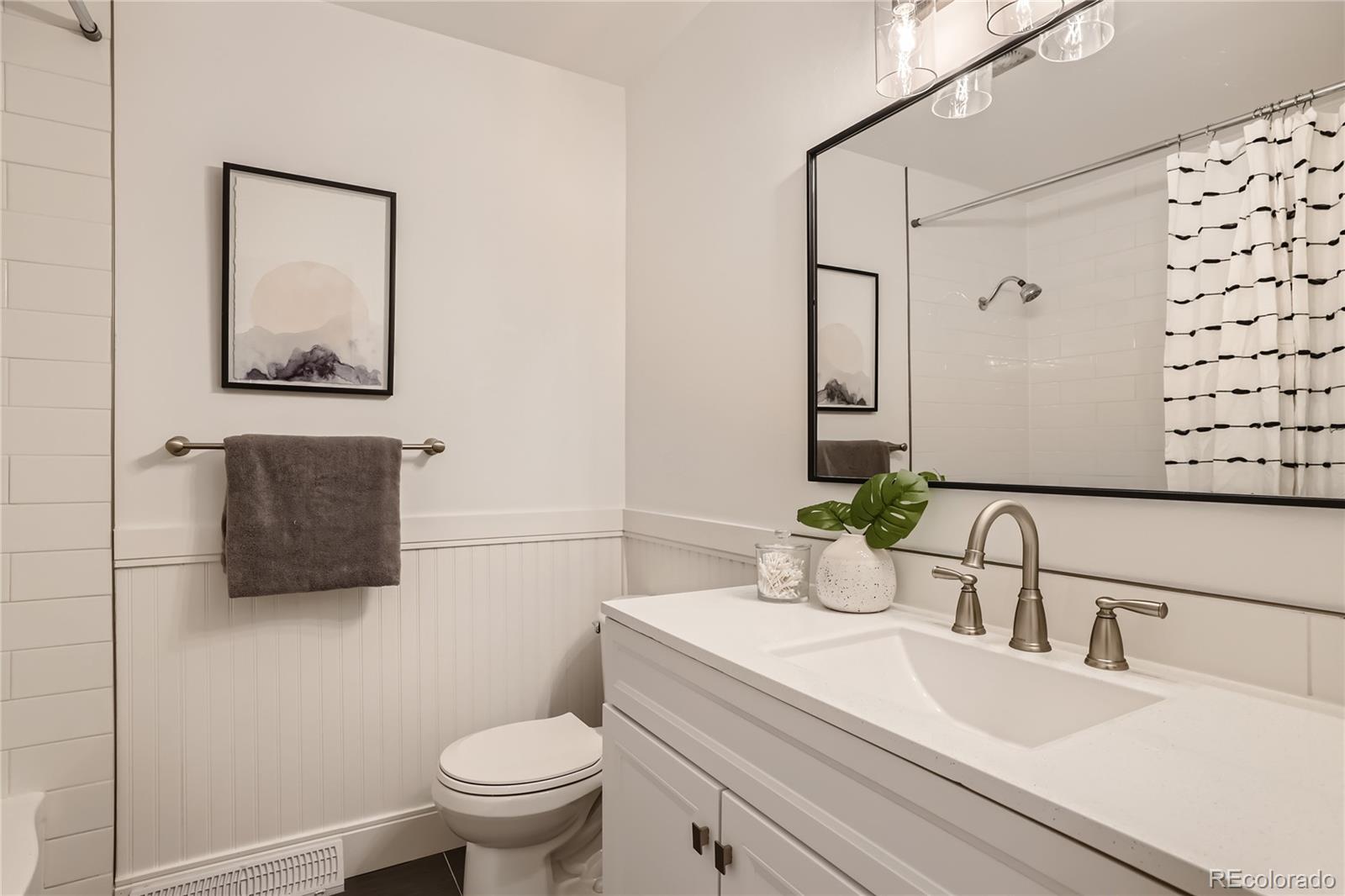 11676 West 37th Place Wheat Ridge, CO 80033 - Photo 12 of 30 a bathroom with a sink a toilet and mirror