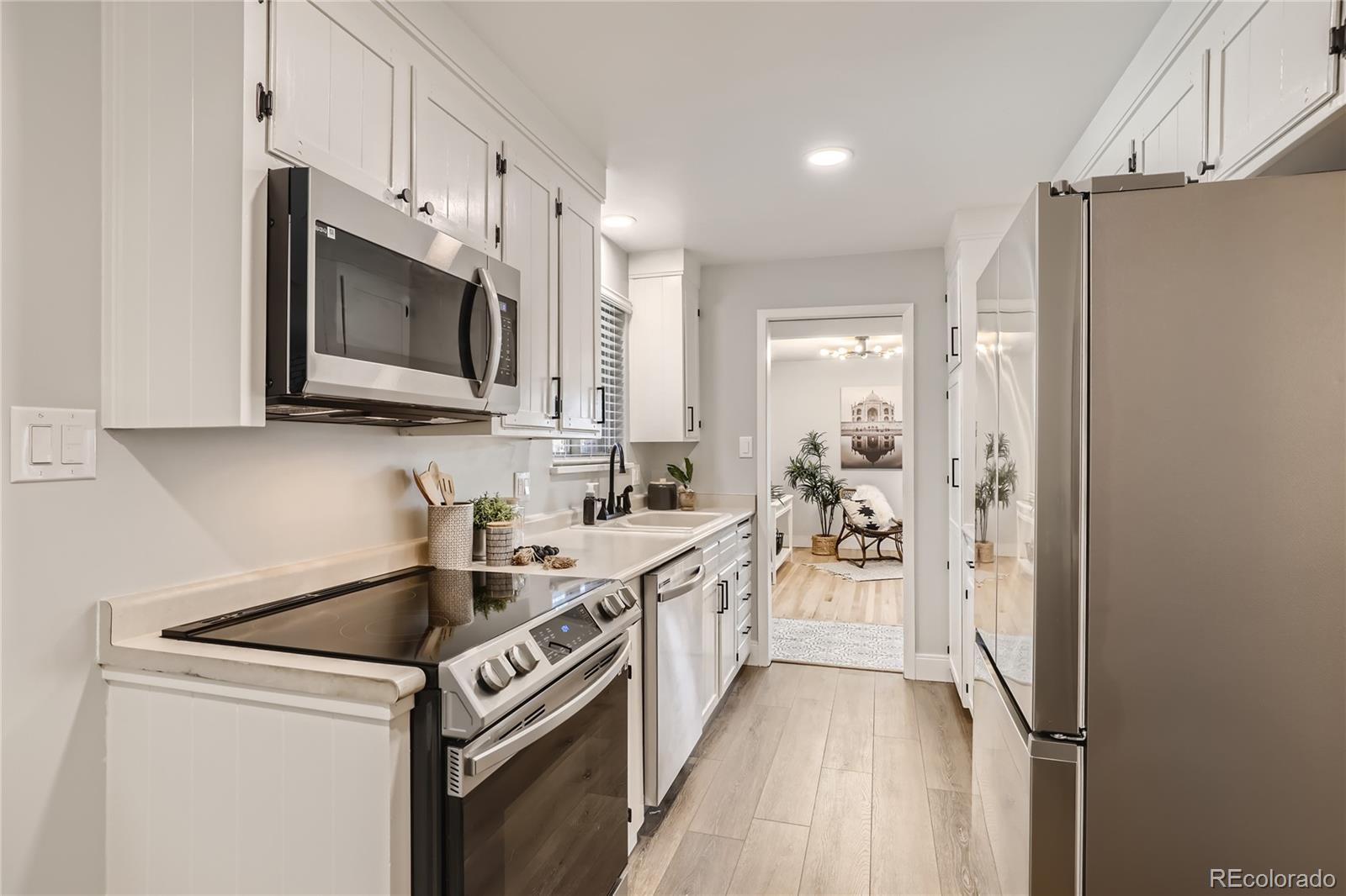 11676 West 37th Place Wheat Ridge, CO 80033 - Photo 7 of 30 a kitchen with a sink stove and microwave