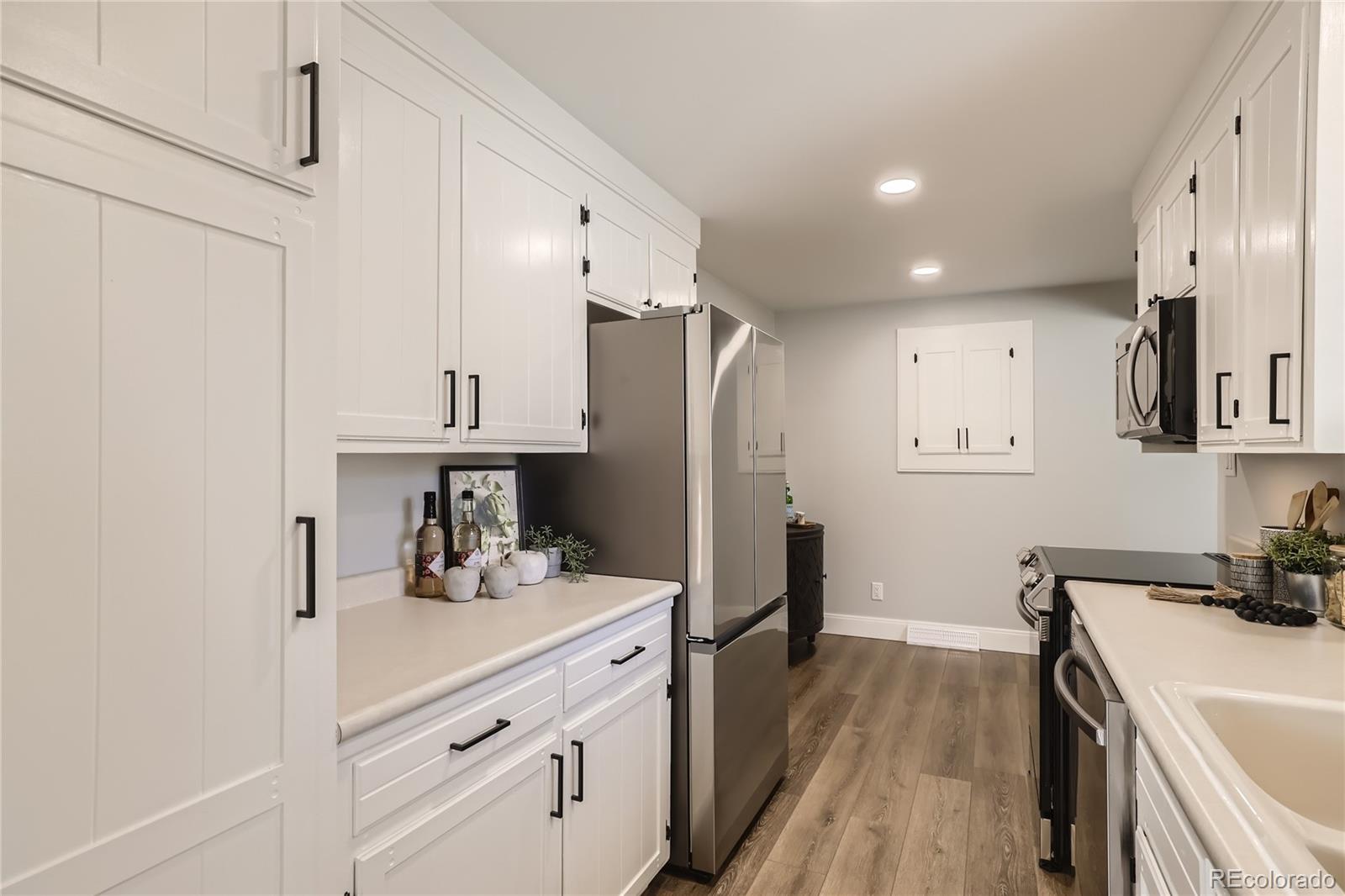 11676 West 37th Place Wheat Ridge, CO 80033 - Photo 9 of 30 a kitchen with a sink a refrigerator and cabinets