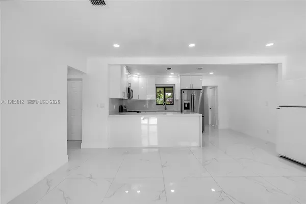 a view of kitchen with furniture and refrigerator
