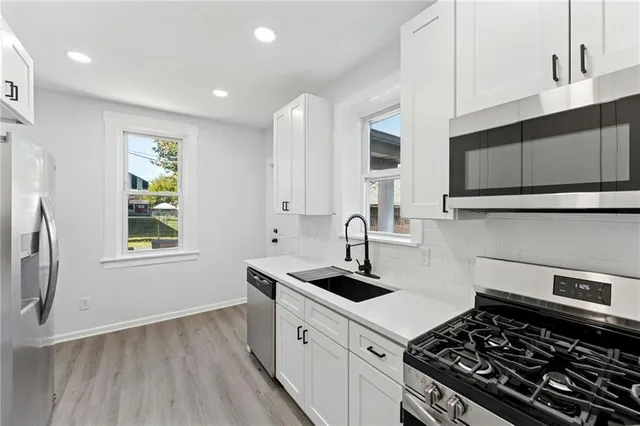 a kitchen with sink a stove and cabinets