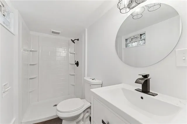 a bathroom with a toilet a sink and mirror