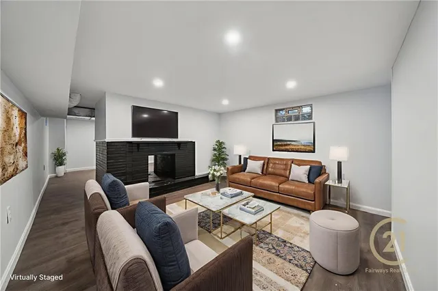a living room with furniture a flat screen tv and a fireplace