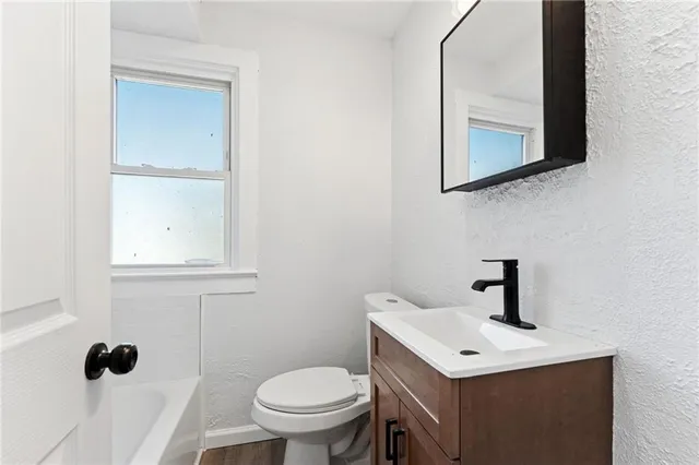 a bathroom with a toilet a sink and mirror